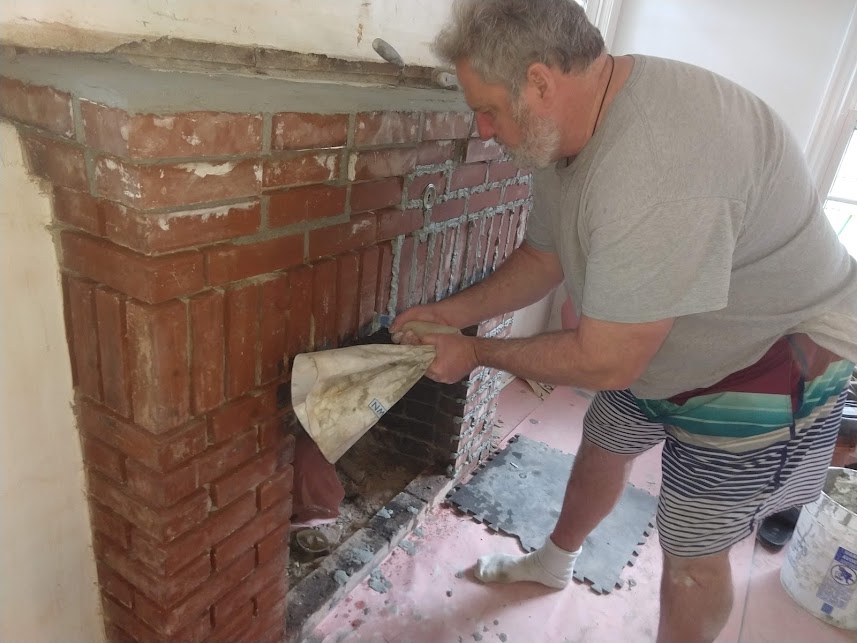 Tuckpointing a brick fireplace mantle.