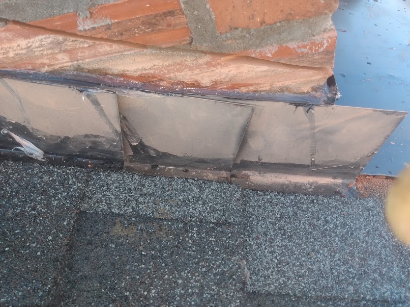 Roof flashing up against a chimney